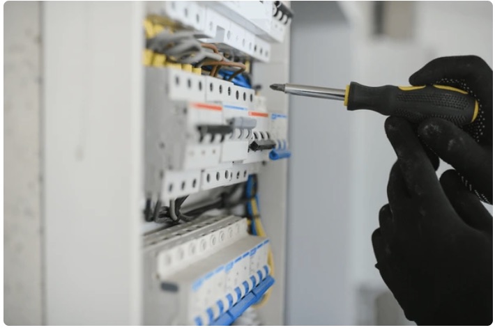 Monteur schroeft een installatieautomaat vast in een groepenkast