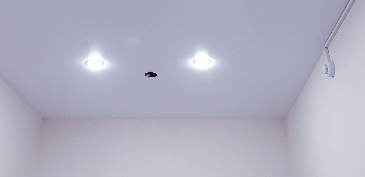Twee rookmelders aan een plafond, gekoppeld en op netspanning aangesloten