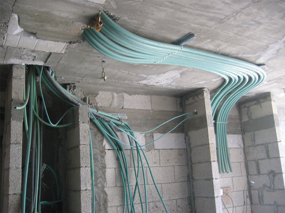 Gebundelde installatiebuizen langs het plafond van een pand in aanbouw